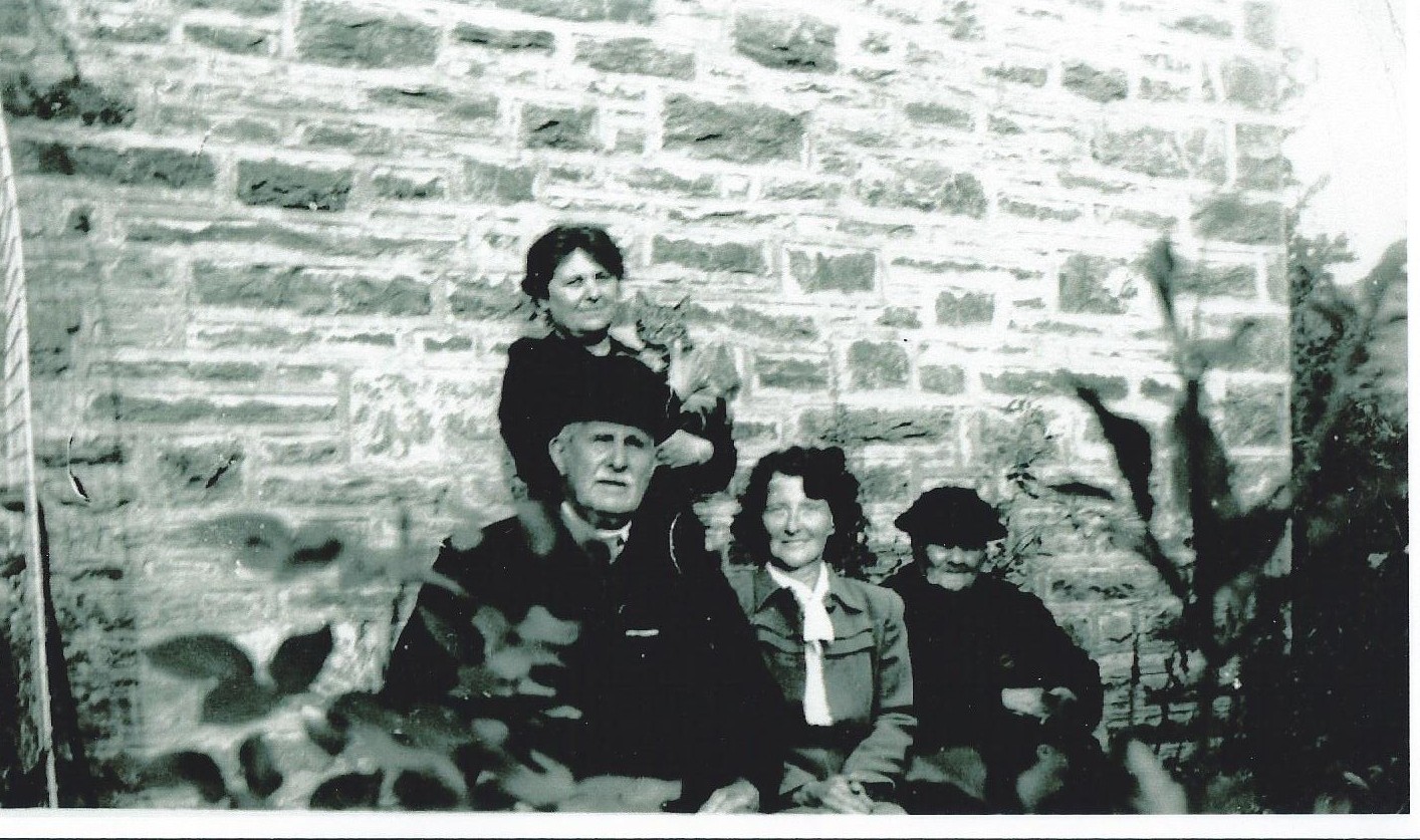 Mary Ann Daniels holds the family tabby in 1940.  Seated in front are her parents and their evacuee guest