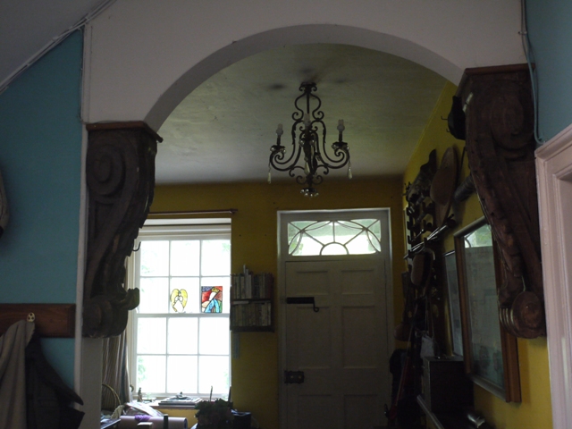 Massive carved consoles support a modern archway in the hall